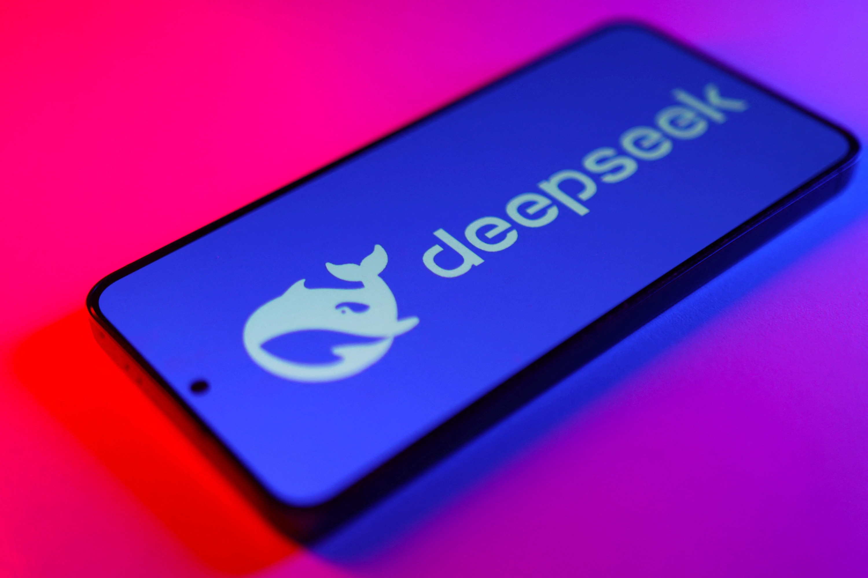 A smartphone shows the DeepSeek whale logo and company name.