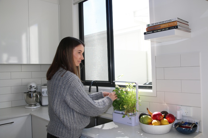 Georgia picks some herbs in her kitchen in her new.