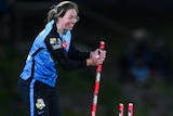 Amanda-Jade Wellington smiles while holding a stump as Mignon Du Preez runs towards her