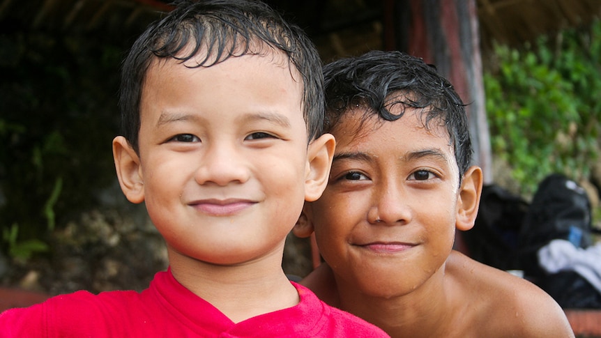 Two young brothers with wet hair from swimming.