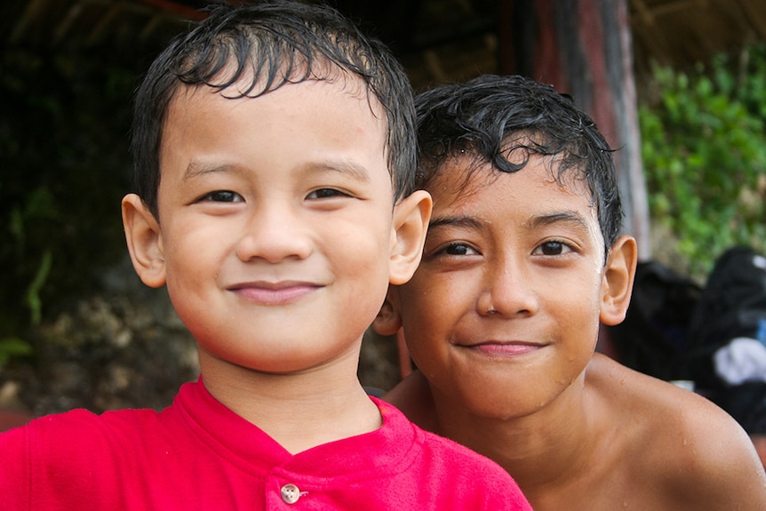 Two young brothers with wet hair from swimming.