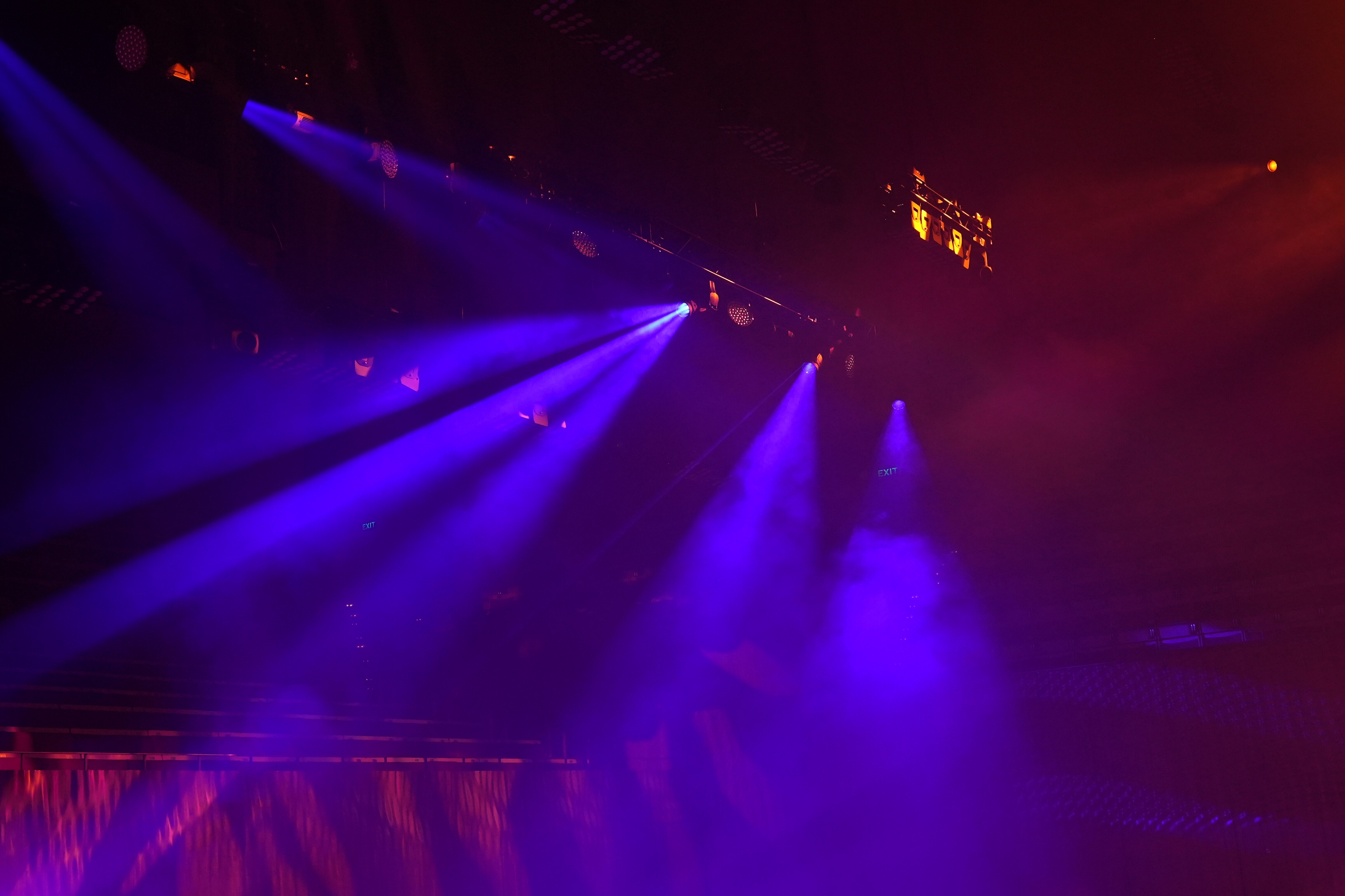 Stage lit up by beams of purple light.
