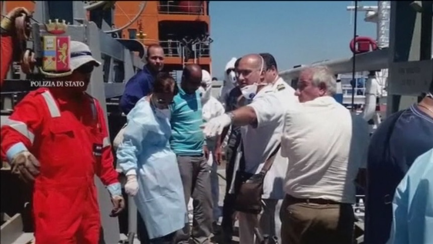 Italian medics assist refugees on a ship in Sicily, Italy on July 20, 2014.