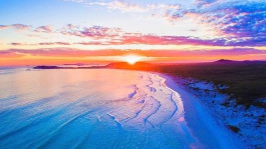 A drone photo of an orange sunset over the beach at Esperance.