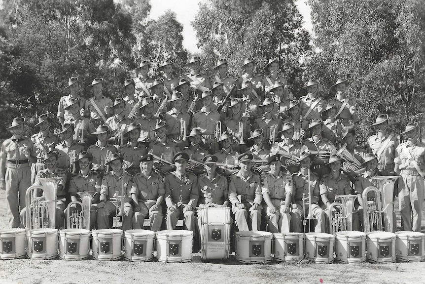 An old black and white photo of about three dozen men wearing army uniform and holding musical instruments