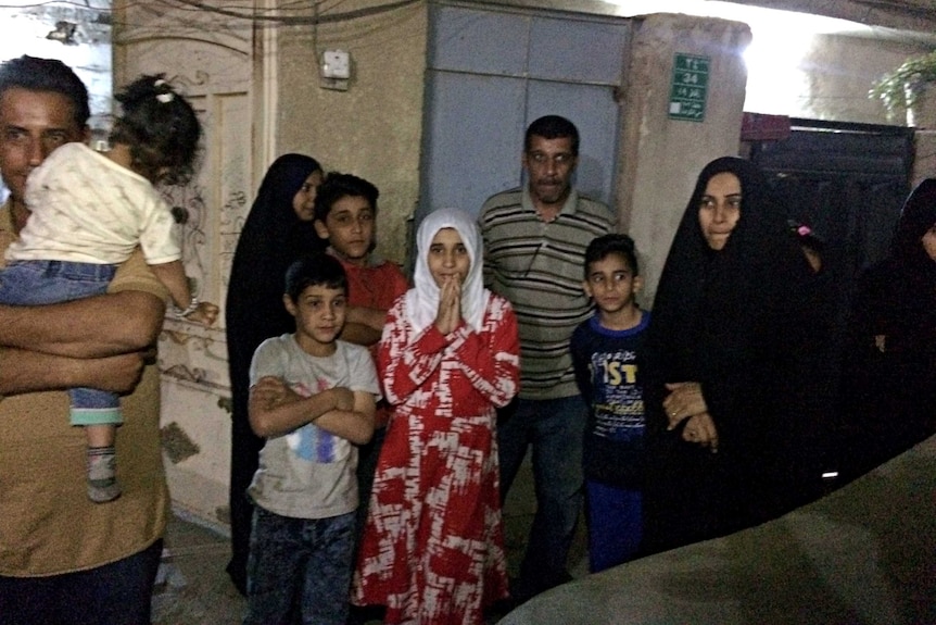 People stand in the street after feeling aftershocks from an earthquake in Baghdad.