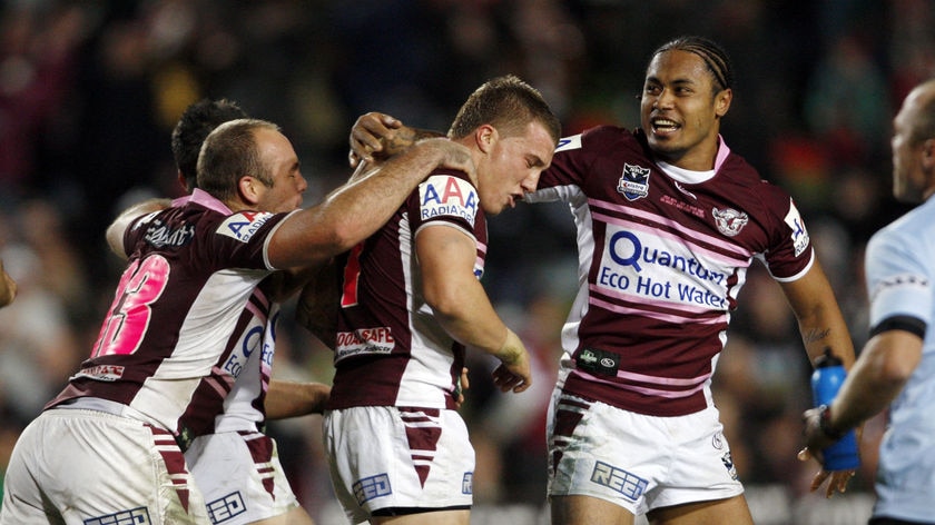 Man of the hour: Manly team-mates congratulate Hodgkinson on his winning field goal.