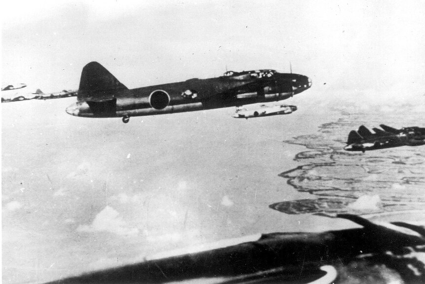 A black-and-white photo of Japanese warplanes flying above the Australian coast.