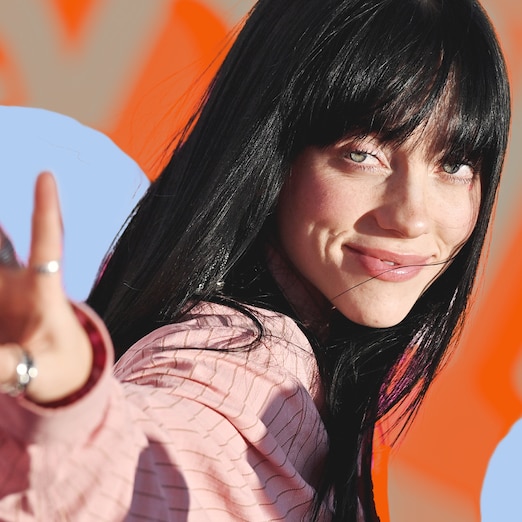 Billie Eilish holding up a peace sign and smiling