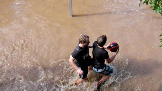 Two men relax with a game of basketball in the floods at Wagga Wagga.