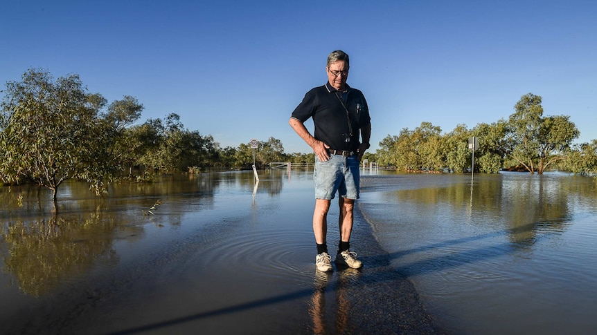 Publican Jim Smith stands in shallow floodwaters.