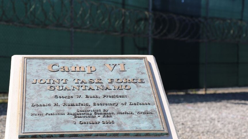 Written on a plaque is Camp VI joint task force Guantanamo.