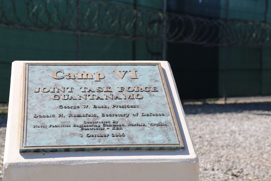 Written on a plaque is Camp VI joint task force Guantanamo.