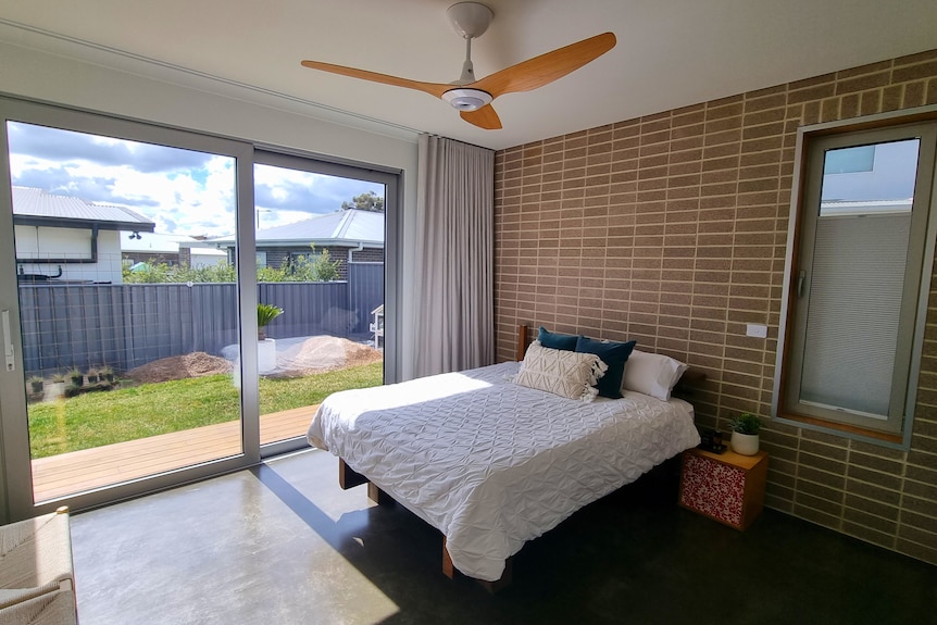 A bedroom with a large window.