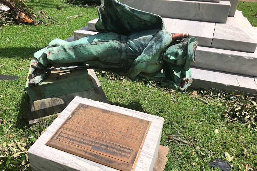 A broken statue of a Confederate soldier lies on the ground in front of a courthouse in Lake Charles.
