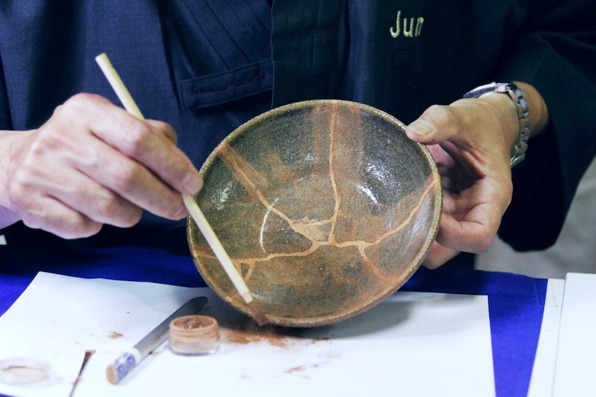 Close up shot of plate being dusted with gold powder.