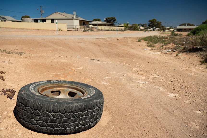 A car tyre on a orange dirt road 