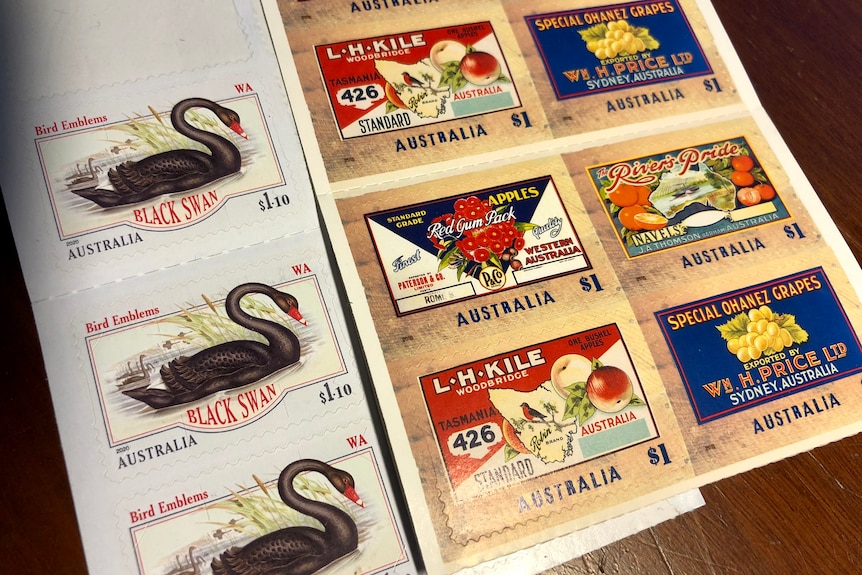 A selection of Australian postage stamps depicting fruit and a black swan.