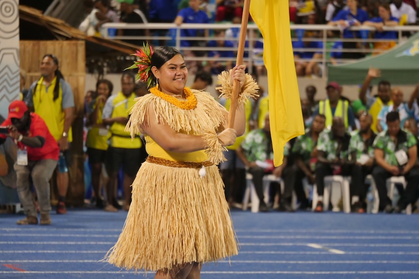 Niue athlete Ramsi Edwards caries the flag.