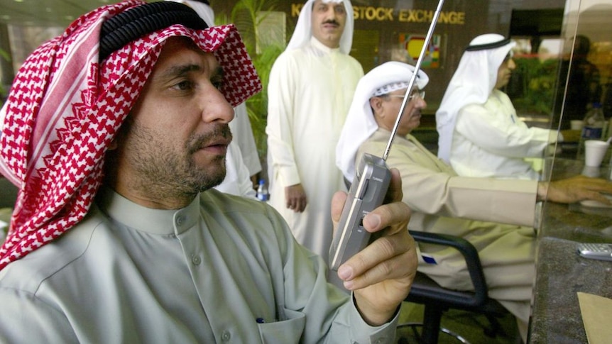 A Kuwaiti man with head scarf listens to BBC Arabic on a small portable radio