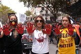 Three women with blood on their hands