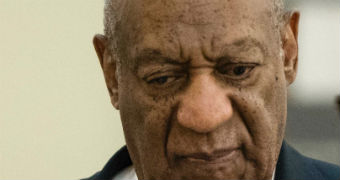 A closeup of Bill Cosby with his eyes down next to spokesperson Andrew Wyatt.