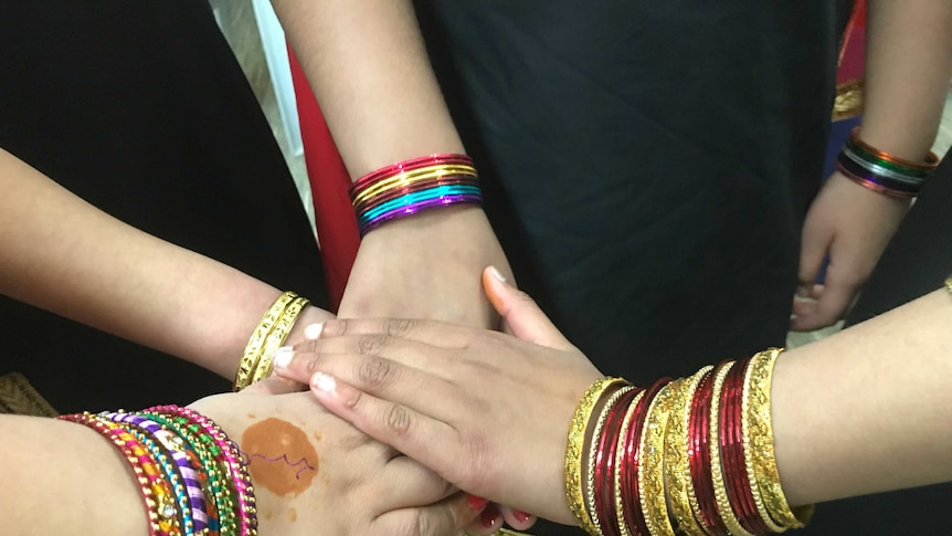 Girls hands with lots of colourful bracelets on their arms