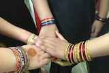 Girls hands with lots of colourful bracelets on their arms