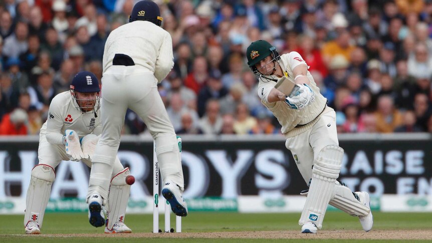 Silly point leaps while the ball goes past him. Steve Smith is eyeing the ball intently as he completes his cover drive.