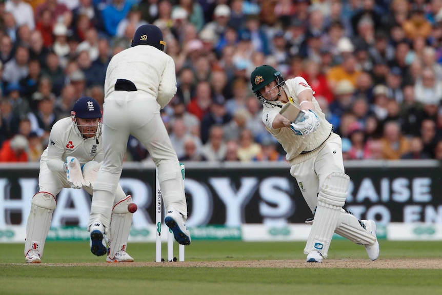 Silly point leaps while the ball goes past him. Steve Smith is eyeing the ball intently as he completes his cover drive.