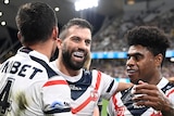 Sydney Roosters players (left to right) Joey Manu, James Tedesco and Kevin Naiqama hug after an NRL try.