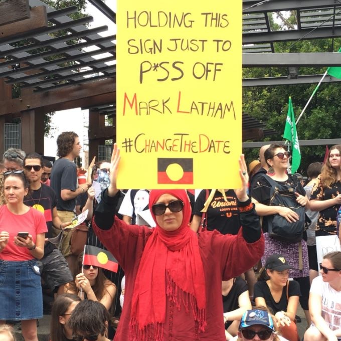Woman holding a sign saying: "Holding this sign just to p*ss off Mark Latham"
