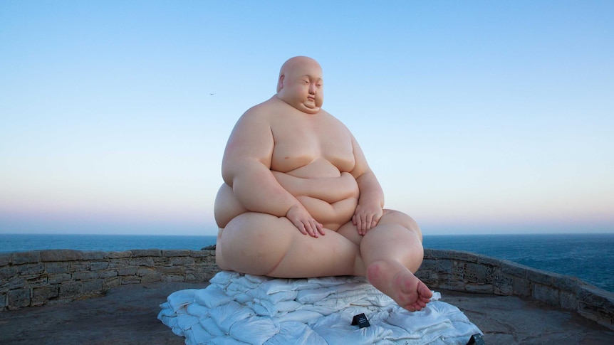 Sculpture “Horizon” by sculptor Mu Boyan features a heavily overweight man.