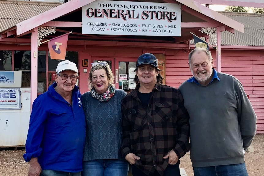 Four people stand outside the Pink Roadhouse.