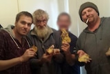 Four men pose with stolen gold.