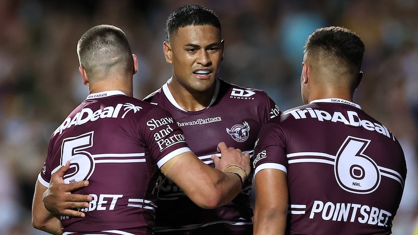 Three Manly Sea Eagles NRL players celebrate a try against Parramatta Eels.