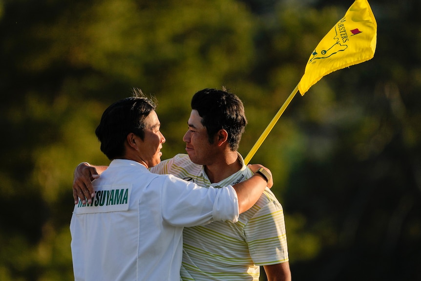 Hideki Matsuyama, of Japan, hugs his caddie Shota Hayafuji