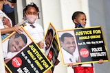 Activists are pictured holding signs saying 'Justice for Ronald Greene, stop police brutality' 