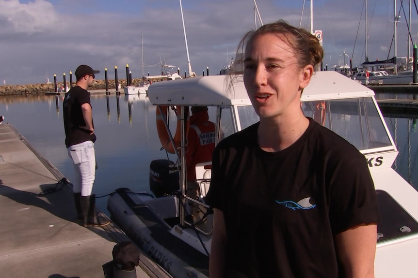 A woman standing in front of a boat