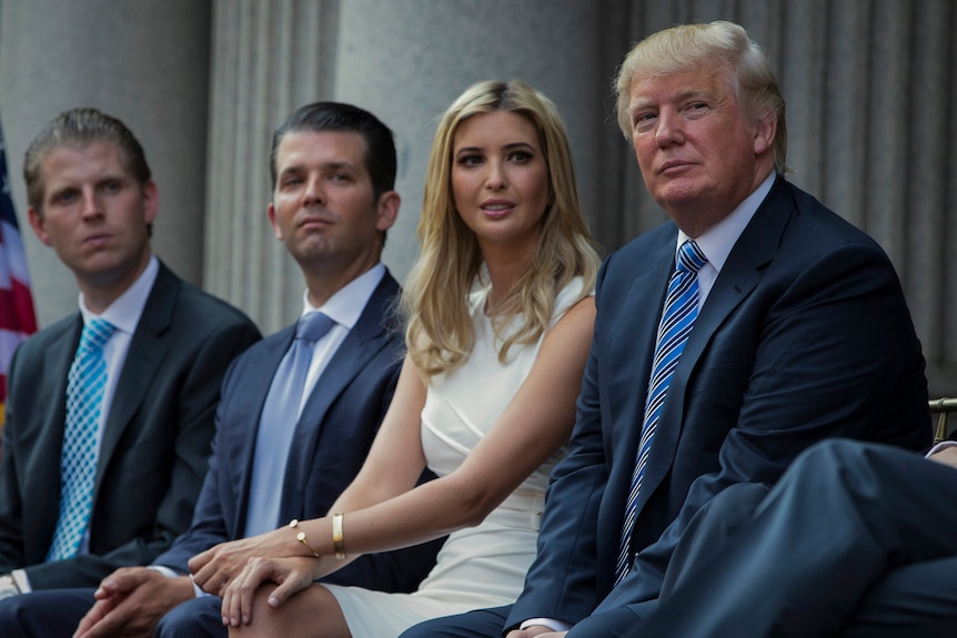 Donald Trump sits with his adult children, Eric, Donald Jr and Ivanka.