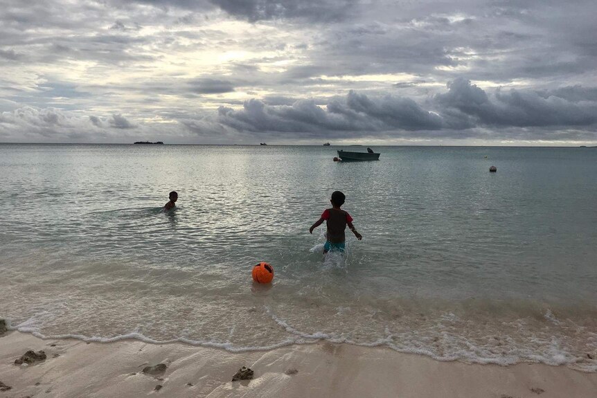 Children play in the waters of Tuvalu's biggest atoll Funafuti.