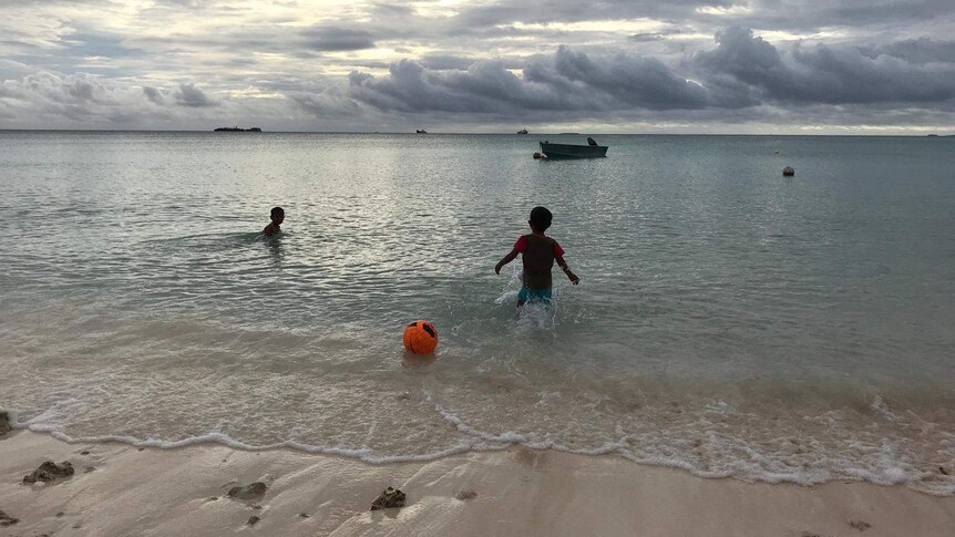 Children play in the waters of Tuvalu's biggest atoll Funafuti.