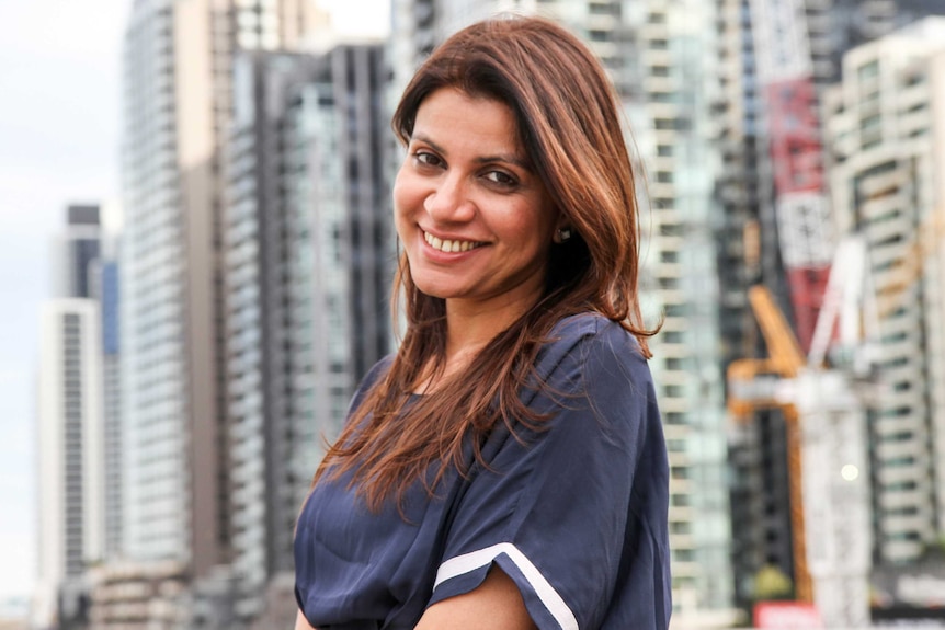 Alankrita Shrivastava, smiling, with buildings out-of-focus in the background.