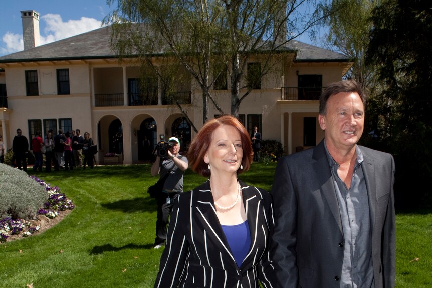 Prime Minister Julia Gillard and her partner Tim Matherson stroll in the gardens after starting residency at the Lodge