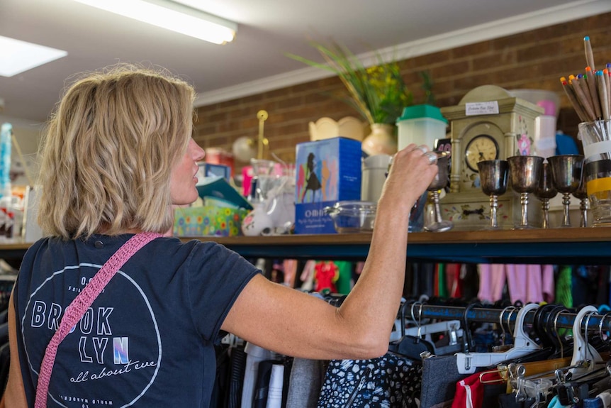 Lisa looking at items in an op-shop.