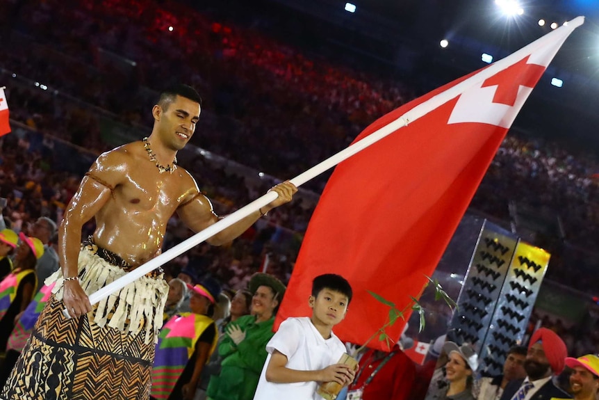 Pita Taufatofua carries the flag for Tonga at the Rio Olympics closing ceremony