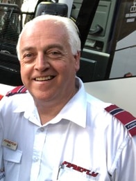 A photo of a smiling grey-haired man.