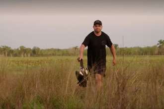 An out of focus photo of a man walking through a paddock 