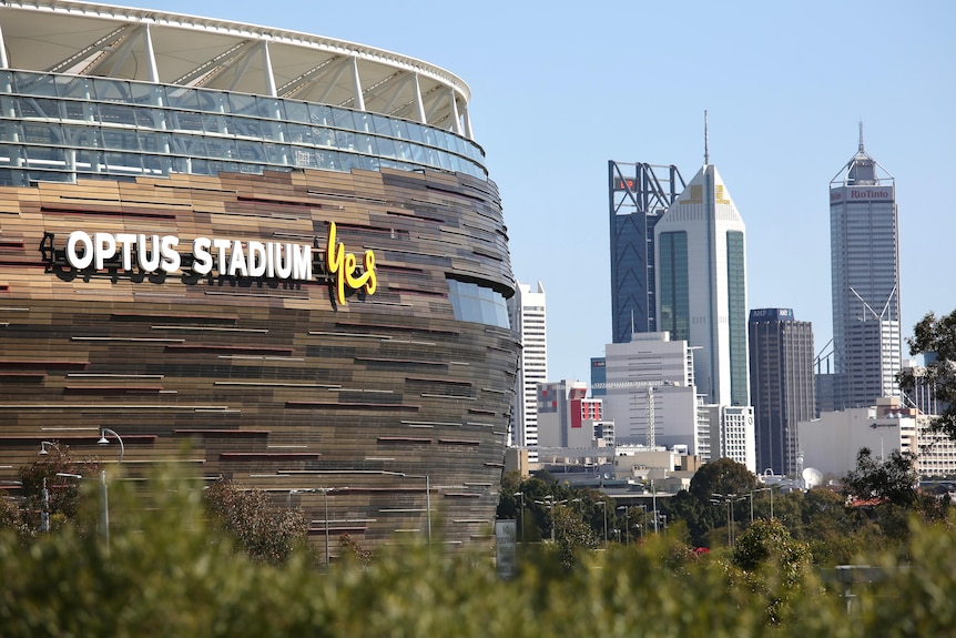 Optus Stadium with the Perth cbd skyline in the background on a sunny day.