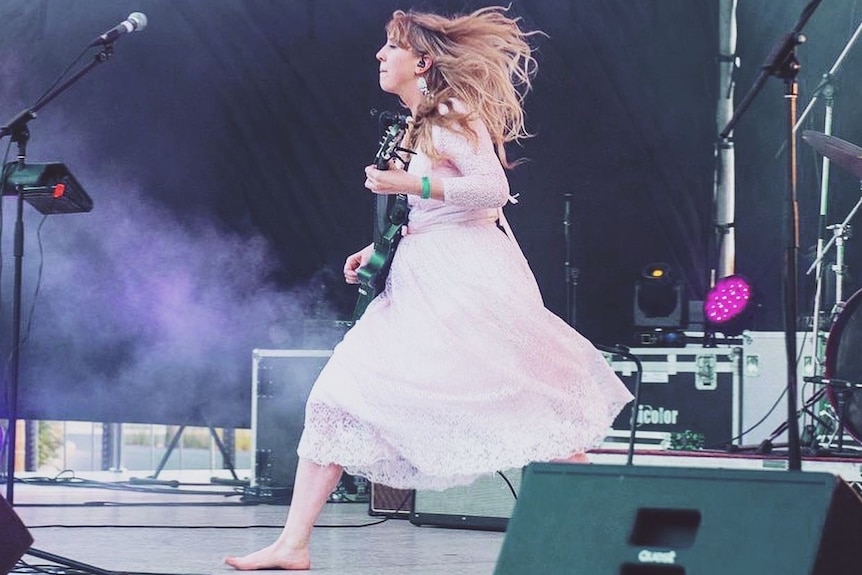 singer running across stage with guitar